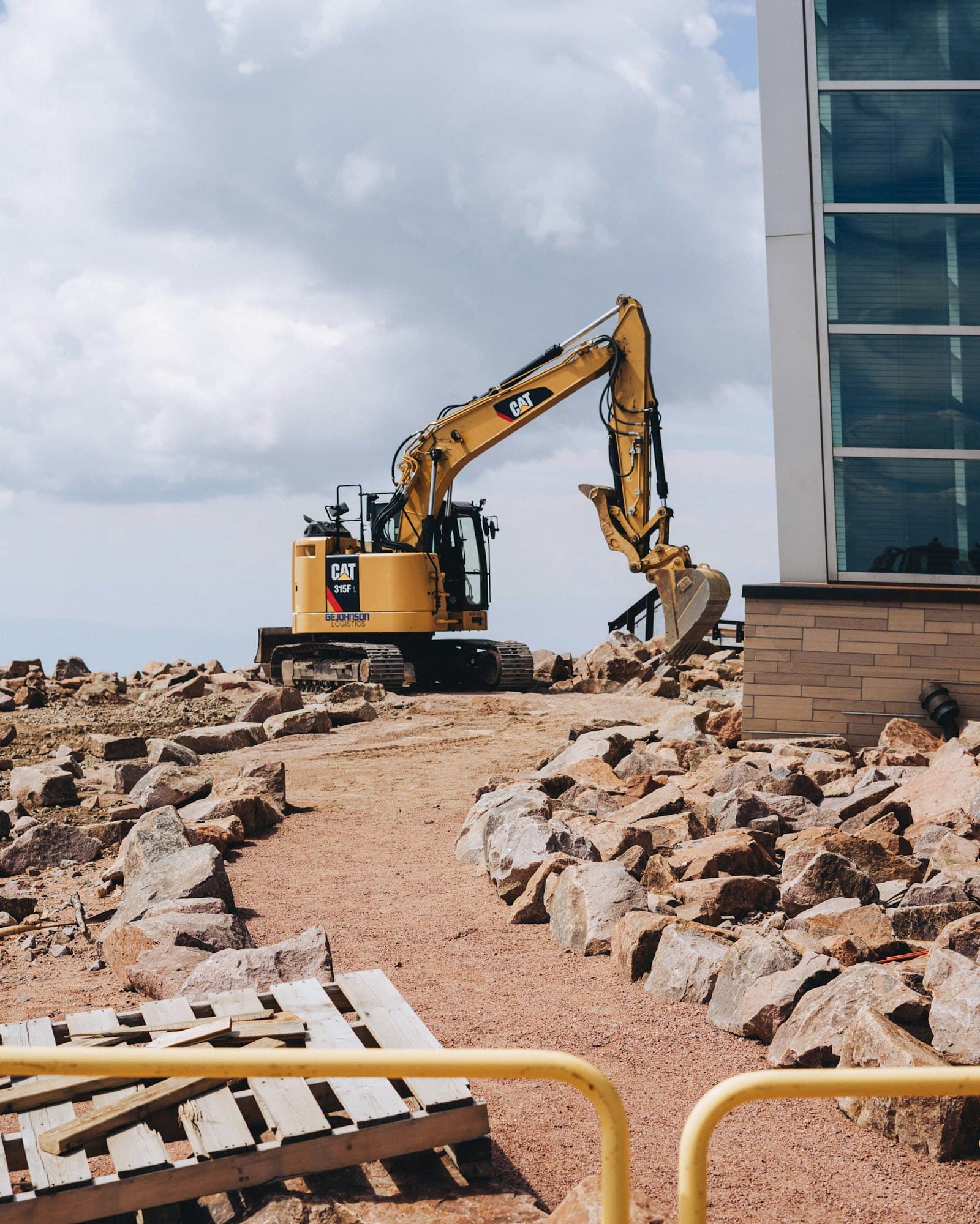 An excavator clearing rubble on a construction site
